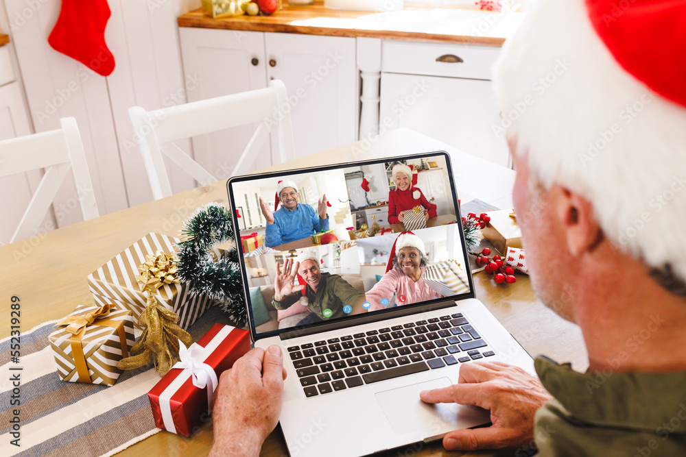 Caucasian man with santa hat having video call with happy diverse friends