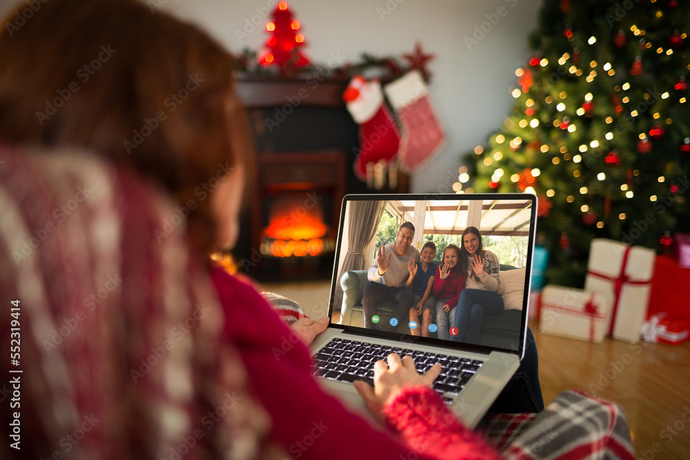Caucasian woman with christmas decorations having video call with happy caucasian family