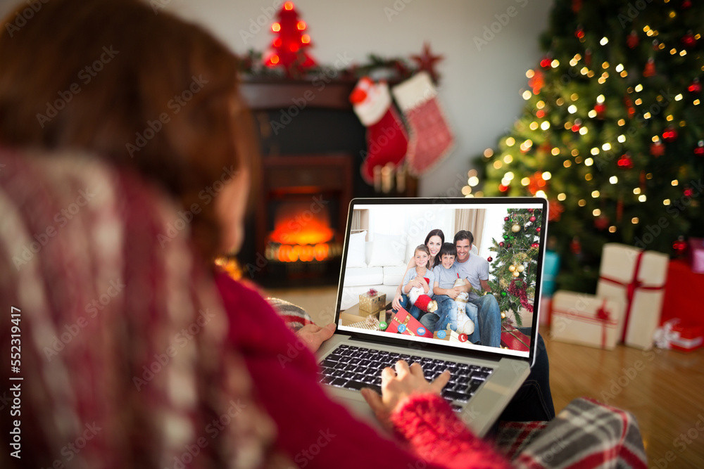 带着圣诞装饰品的高加索妇女与幸福的高加索家庭进行视频通话