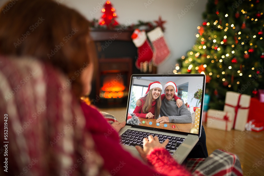 带着圣诞装饰品的高加索妇女与幸福的高加索家庭视频通话
