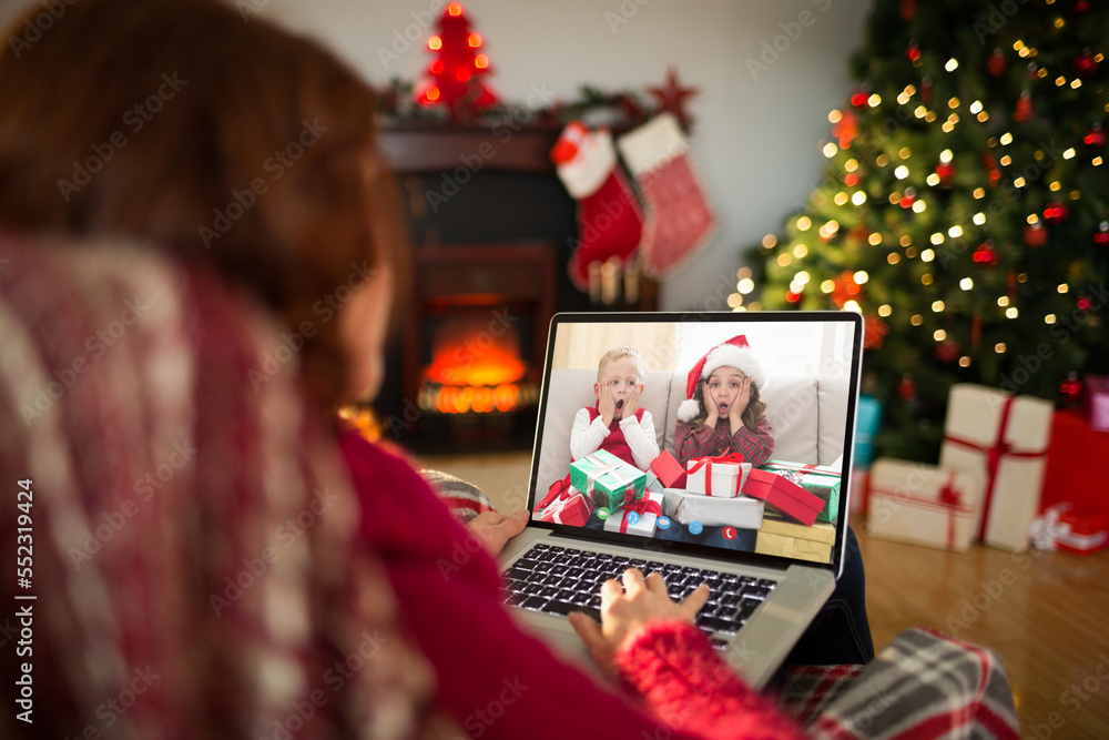 Caucasian woman with christmas decorations having video call with happy caucasian children