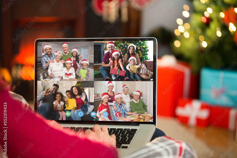 带着圣诞装饰品的高加索妇女与幸福的多元化家庭进行视频通话
