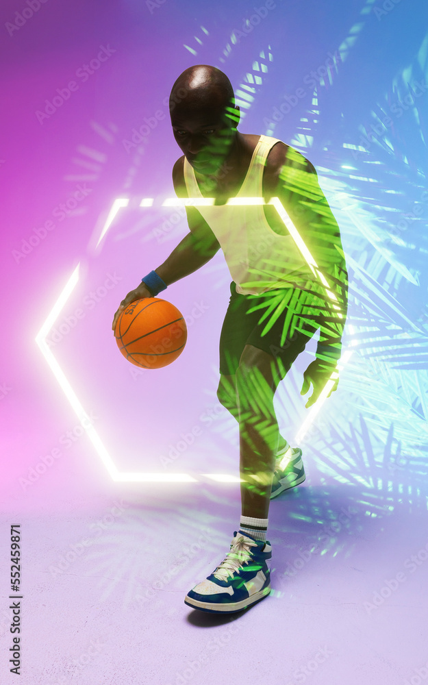 African american male basketball player dribbling ball by illuminated hexagon and plants, copy space