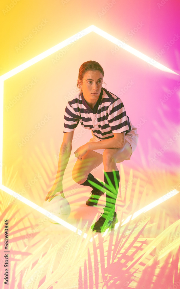 Caucasian female rugby player with ball crouching over illuminated hexagon and plants