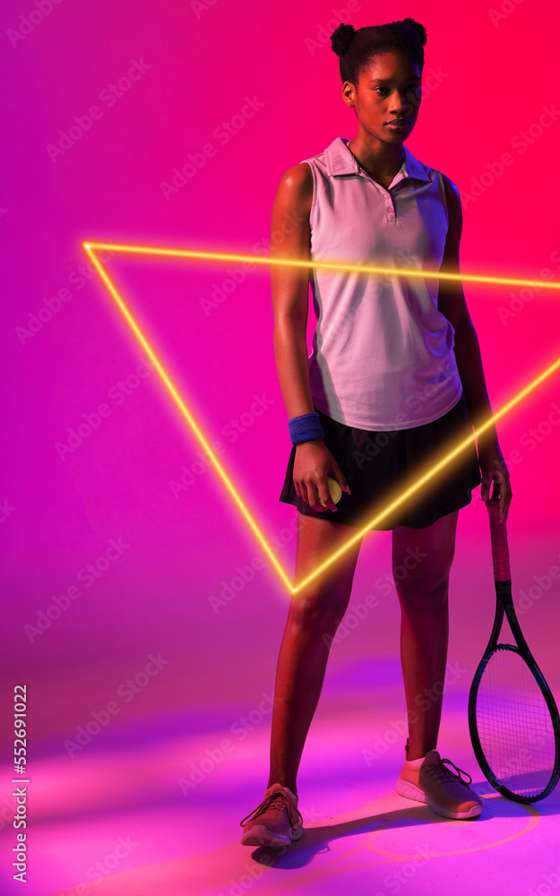 非裔美国女选手用粉红色背景的发光三角形持球和球拍
