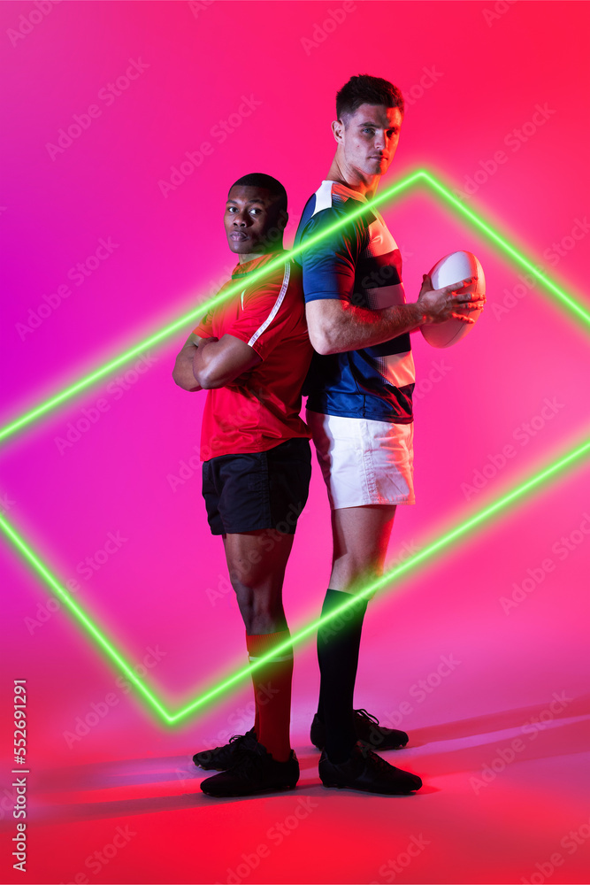 不同的男性橄榄球对手背靠背站在粉红色背景上发光的矩形旁边