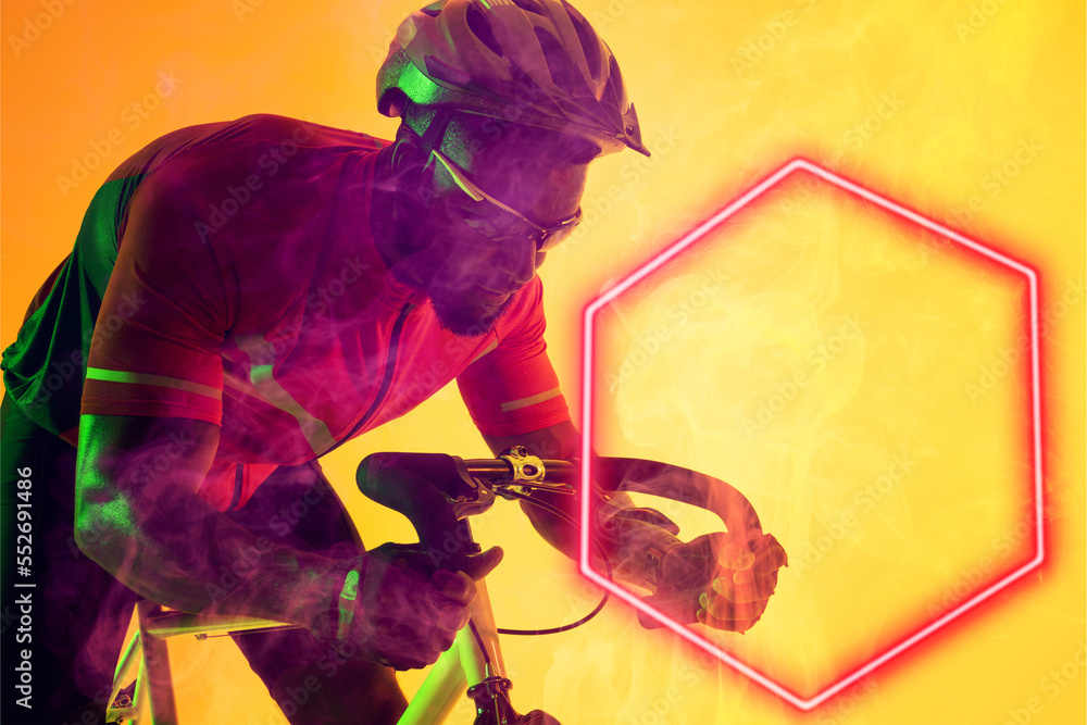 戴着眼镜和头盔的非裔美国男自行车手骑着发光的六边形自行车