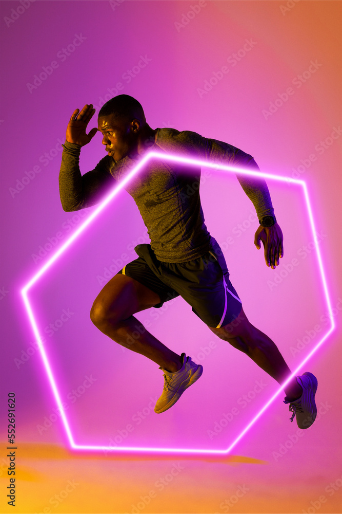 Illuminated hexagon over confident african american male athlete running on gradient background