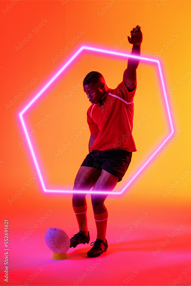 非裔美国男子橄榄球运动员，手持发光六边形踢球