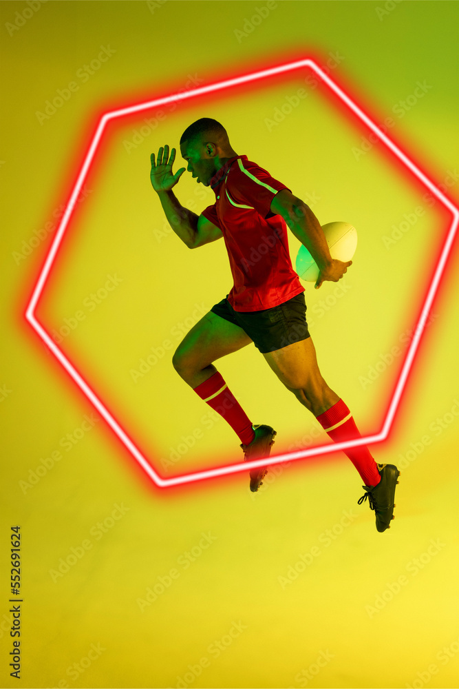 非裔美国男运动员，橄榄球在绿色背景下由发光的六边形奔跑
