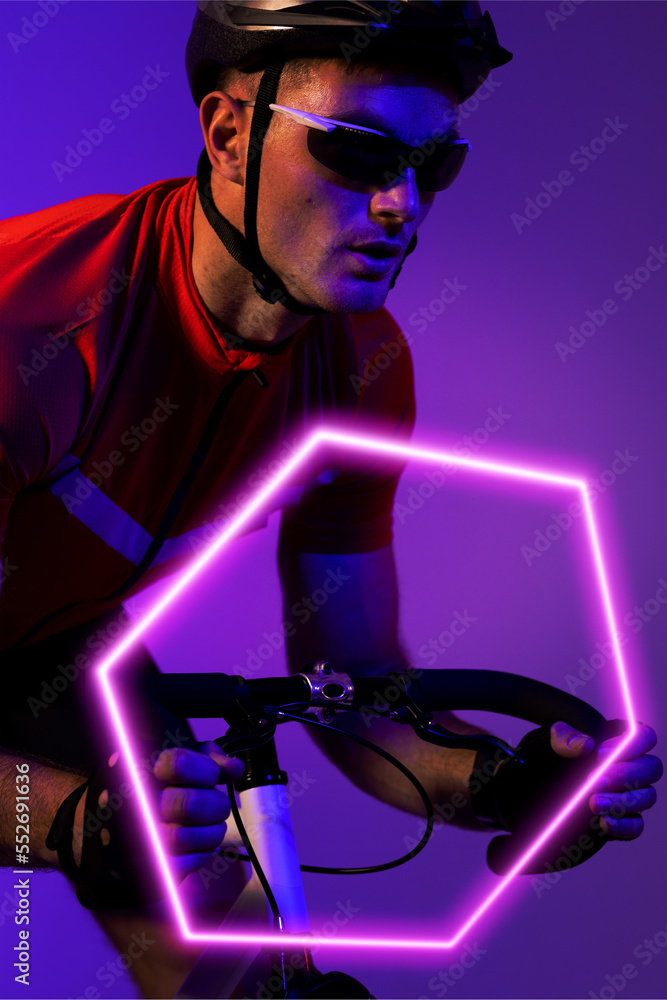 白人男运动员戴着头盔和眼镜，骑着照明六边形的自行车，复制空间