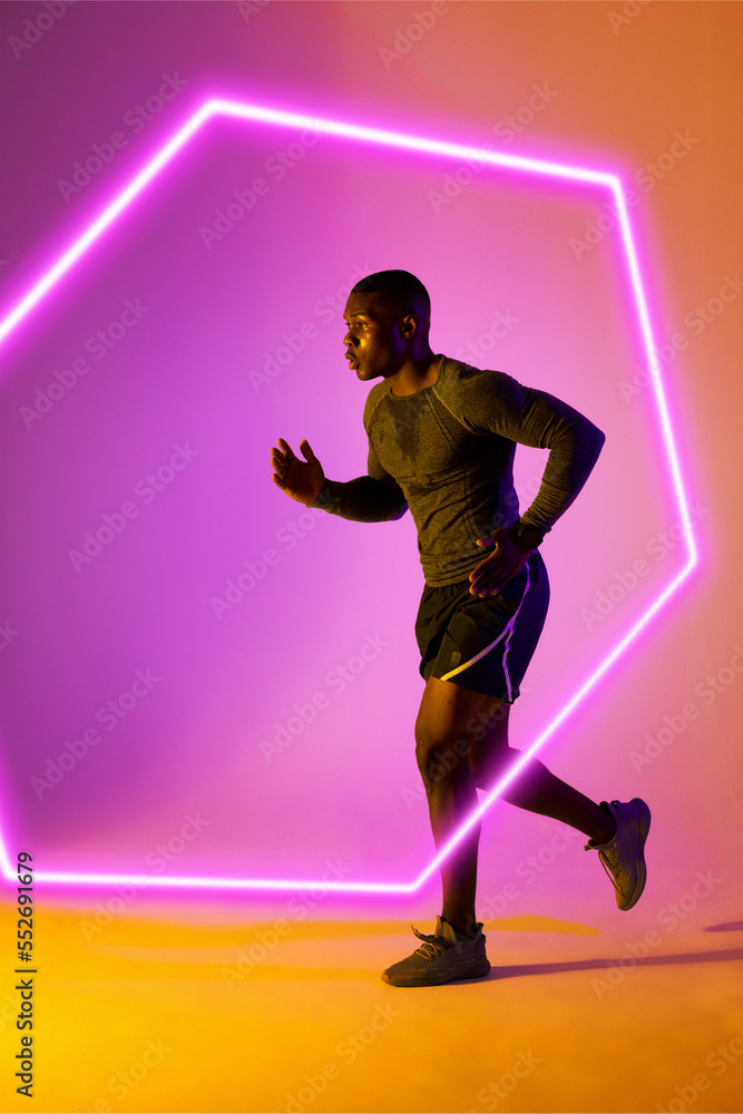 African american male athlete running over illuminated hexagon against gradient background