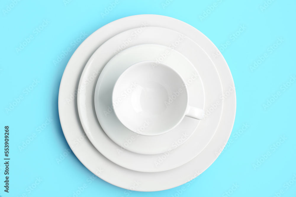 蓝色背景带盘子的白色杯子