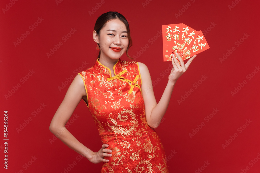 Young asian woman wearing qipao cheongsam dress with red envelopes on red background for Chinese new
