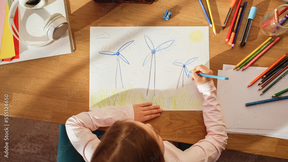 俯视图：小女孩画着漂亮的风力涡轮机，看起来像花。在阳光明媚的日子里，聪明的孩子