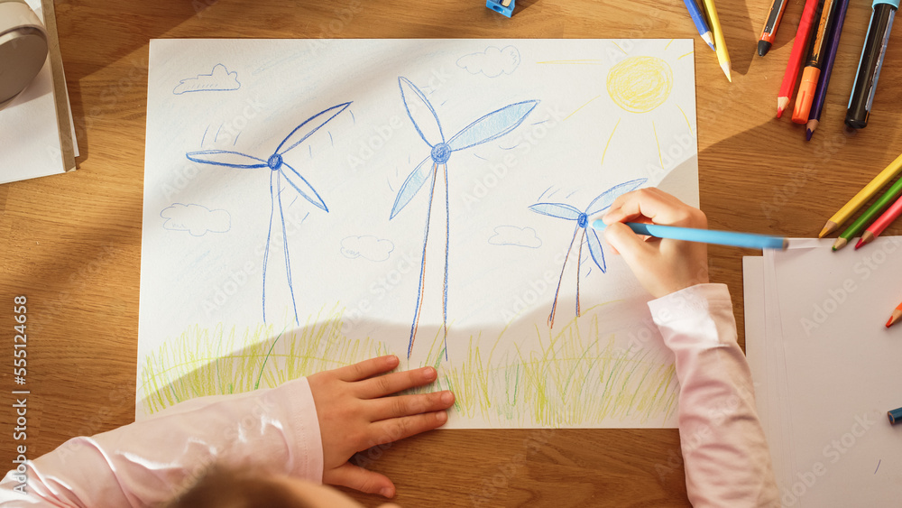 Top View: Little Girl Drawing Beautiful Wind Power Turbines that Look Like Flowers. On Sunny Day Sma