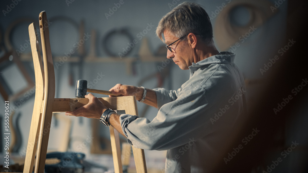 成年木匠戴上眼镜，阅读蓝图，开始组装木制Cha的零件