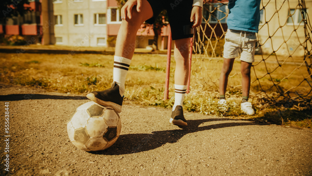 特写镜头：一个年轻男孩用脚挡球。年轻足球运动员准备击球