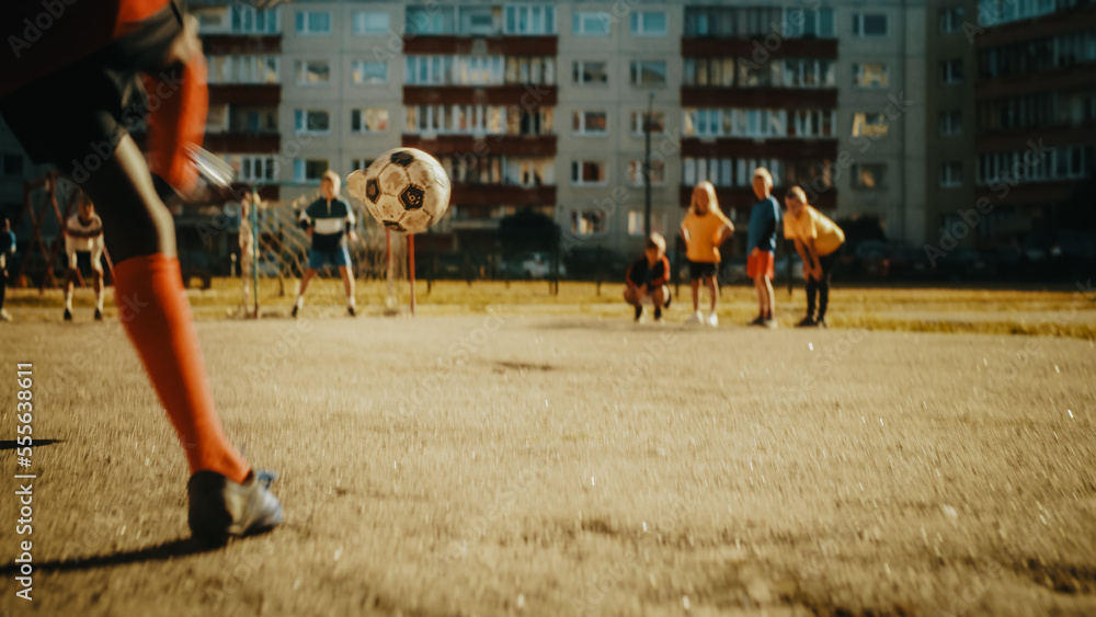 邻里孩子在城市后院踢足球。多元文化的朋友踢足球