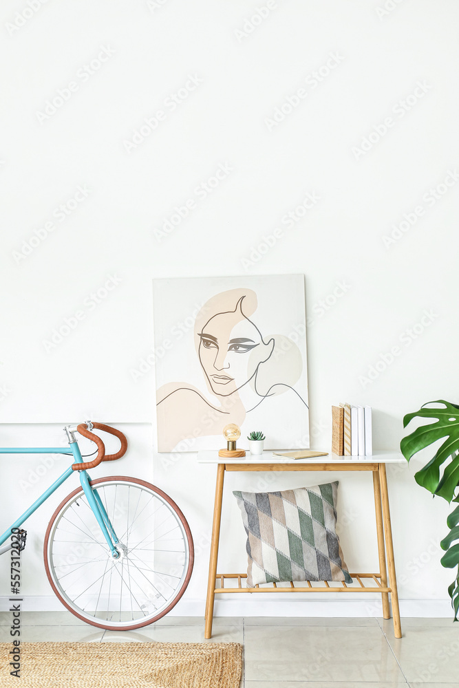 带自行车、桌子和图片的浅色客厅内部