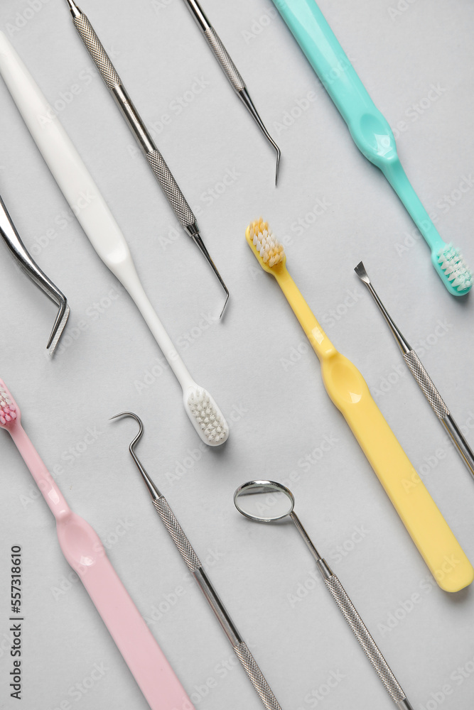 Dental tools with toothbrushes on grey background