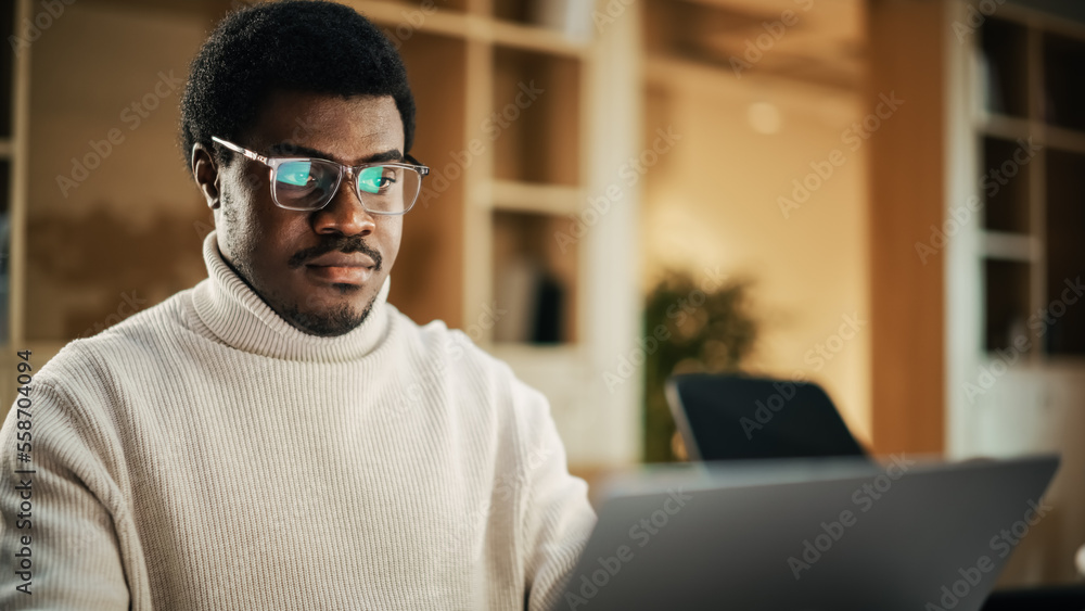 黑人富有创造力的年轻人在临时办公室用笔记本电脑工作的肖像。商人Develo