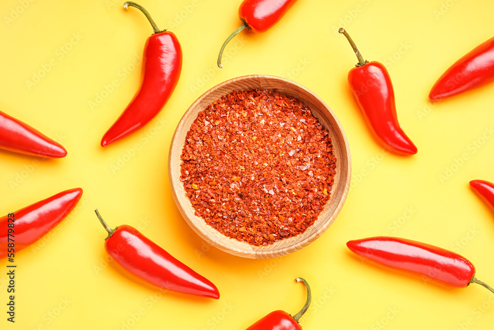 Bowl of chipotle chili flakes and fresh jalapeno peppers on yellow background