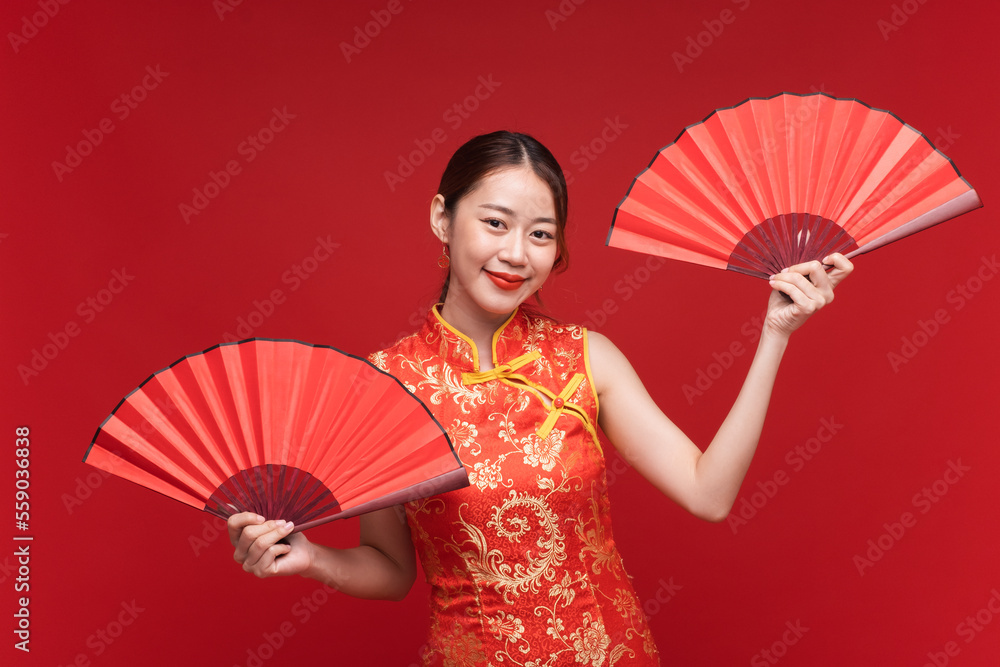 年轻的亚洲女性，身穿中国红底折扇的qipao-cheungsam连衣裙