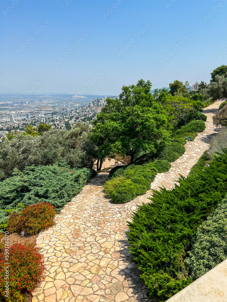 View of stone pathway on hill against cityscape background