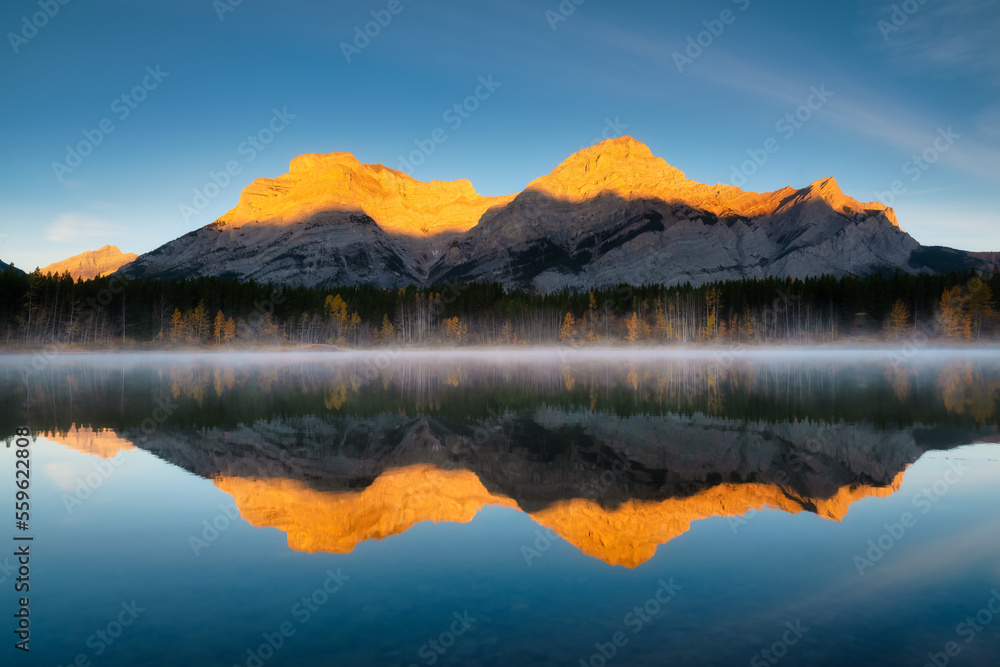 黎明时的山景。雾蒙蒙的早晨。黎明时山谷中的湖泊和森林。倒影