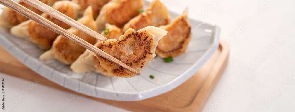 用酱油在白色桌子背景上的盘子里煎饺子饺子饺子。