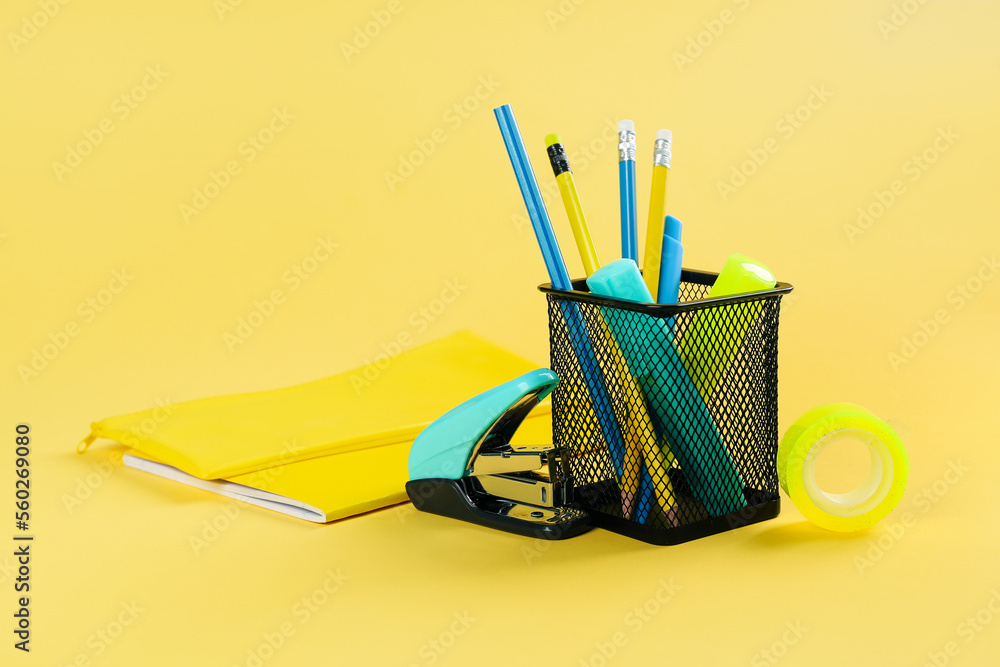 黄色背景带文具和笔记本的支架
