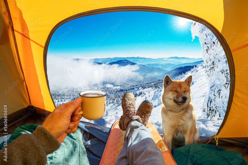 Cup of hot drink in the hand  and wonderful view of snowy mountain tops through the open entrance to