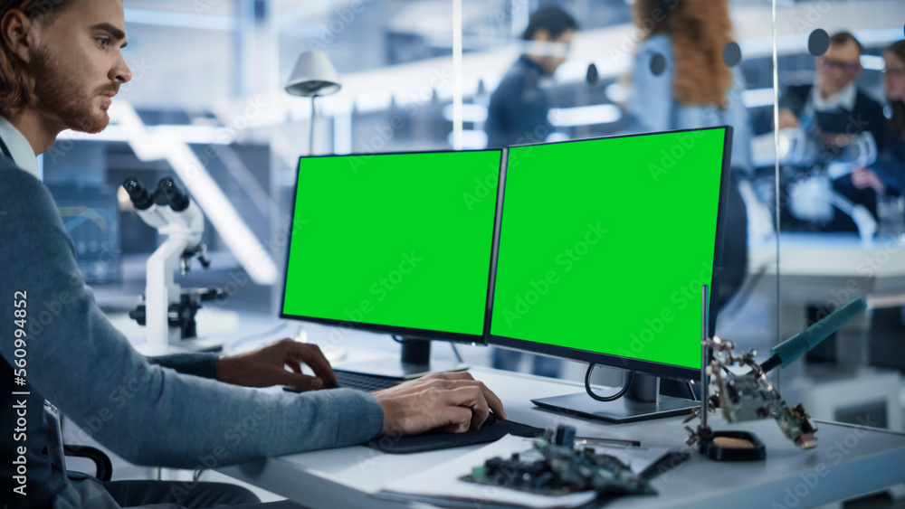 Software Developer Working on Computer with Green Screen Mock Up Display. Scientific Lab, Engineerin