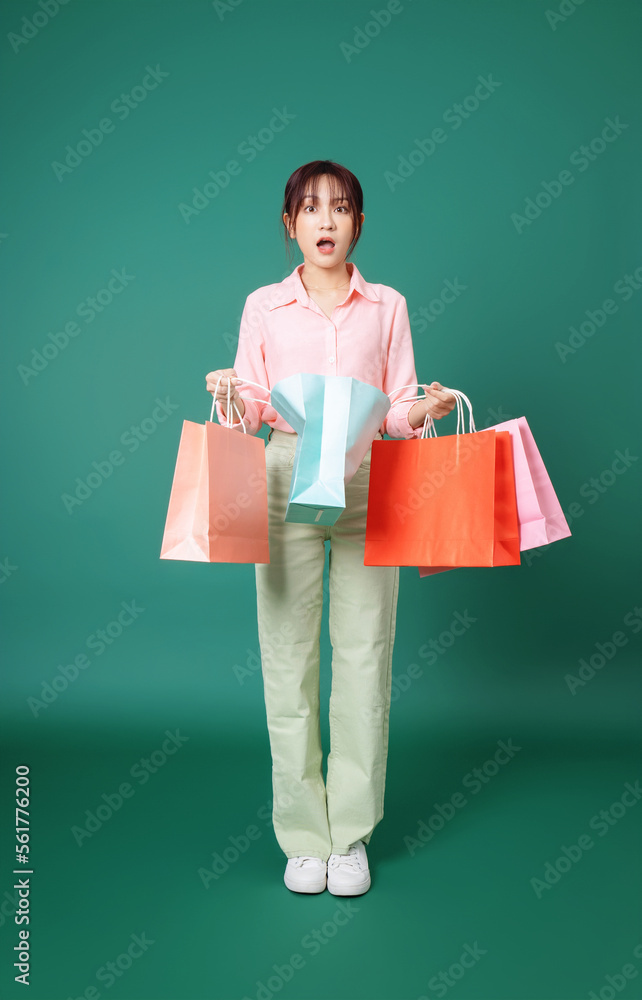 背景是年轻的亚洲女孩拿着购物袋的照片