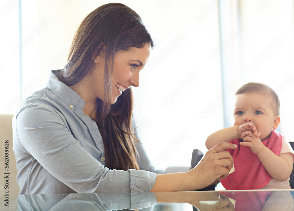 母亲、婴儿和椅子，带着微笑、早晨和幸福，在餐桌上玩耍、亲密和爱。