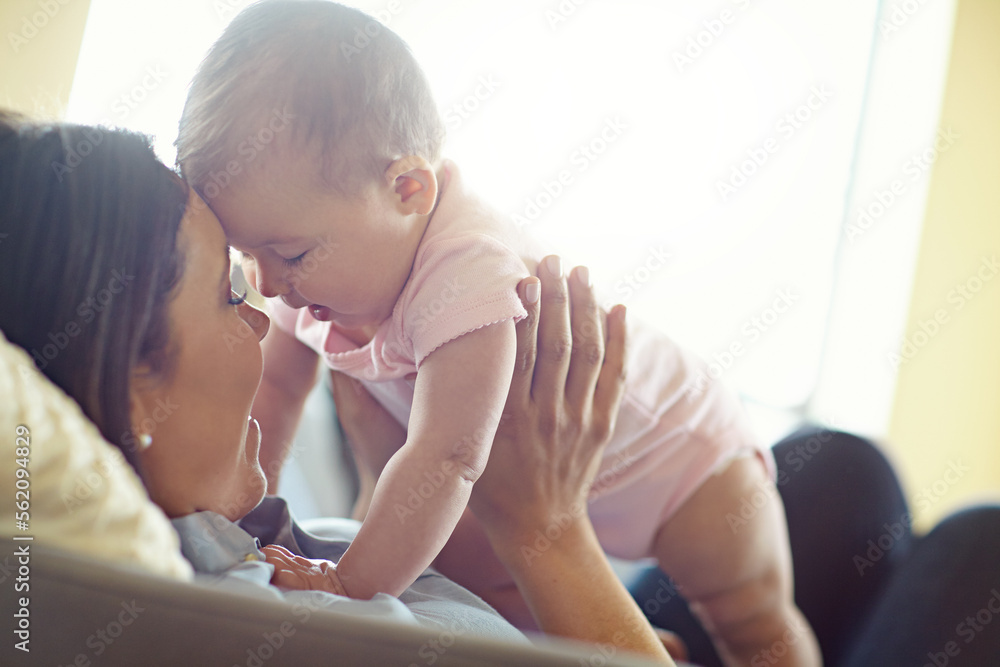 Mom, bonding or forehead touch with baby girl on house living room, relax nursery or family home sof