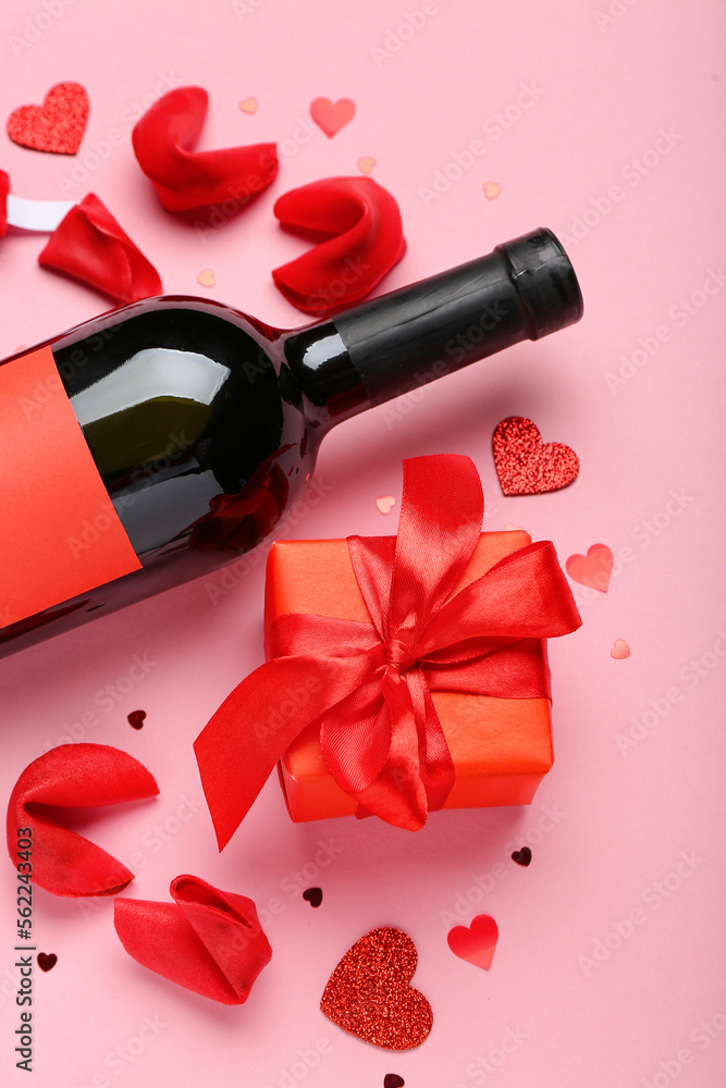 Fortune cookies with gift and bottle of wine on pink background. Valentines Day celebration