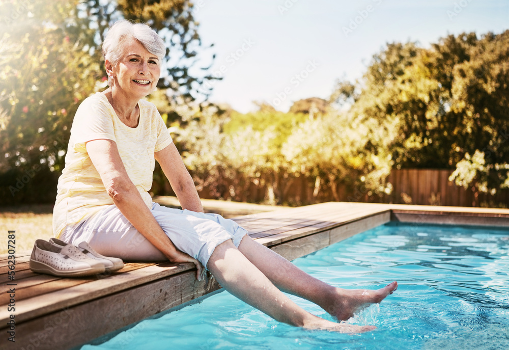 夏天度假、冒险或户外旅行时，脚在游泳池里的老年妇女。Hap