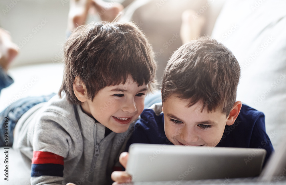 快乐的孩子，在兄弟们的电子竞技、社交活动中，在家庭客厅的放松沙发上建立联系或平板电脑