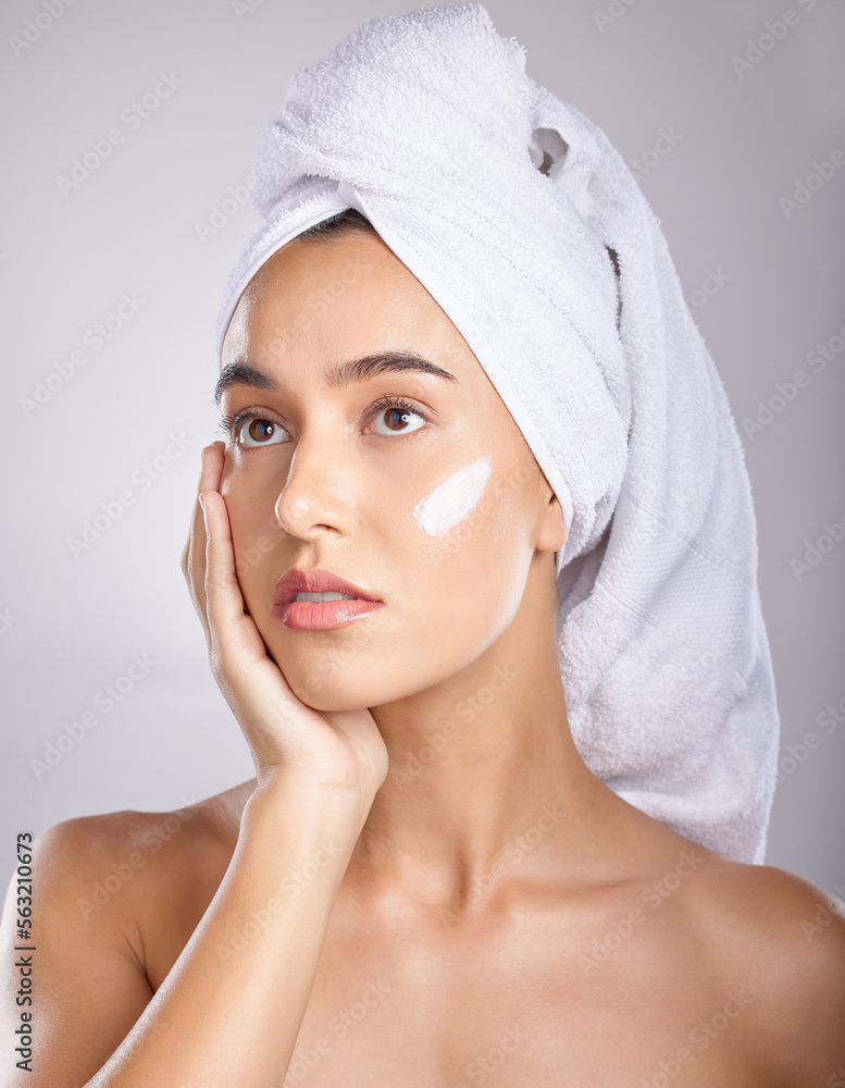女性，化妆、化妆和面部排毒用毛巾和面霜，灰色工作室背景。年轻女性