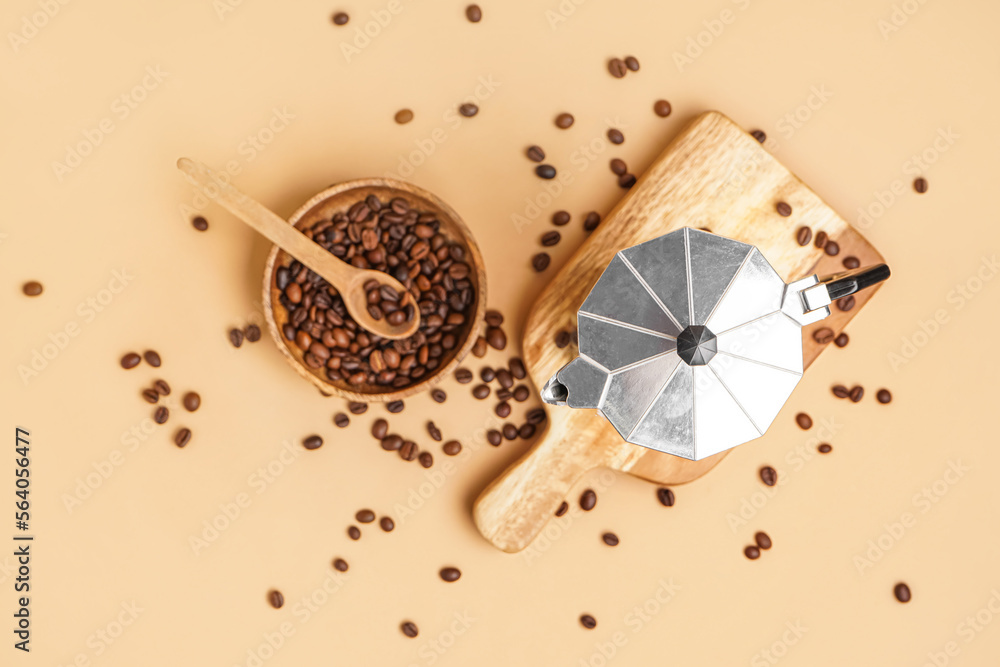 米色背景的带间歇泉咖啡机、咖啡豆和勺子的砧板