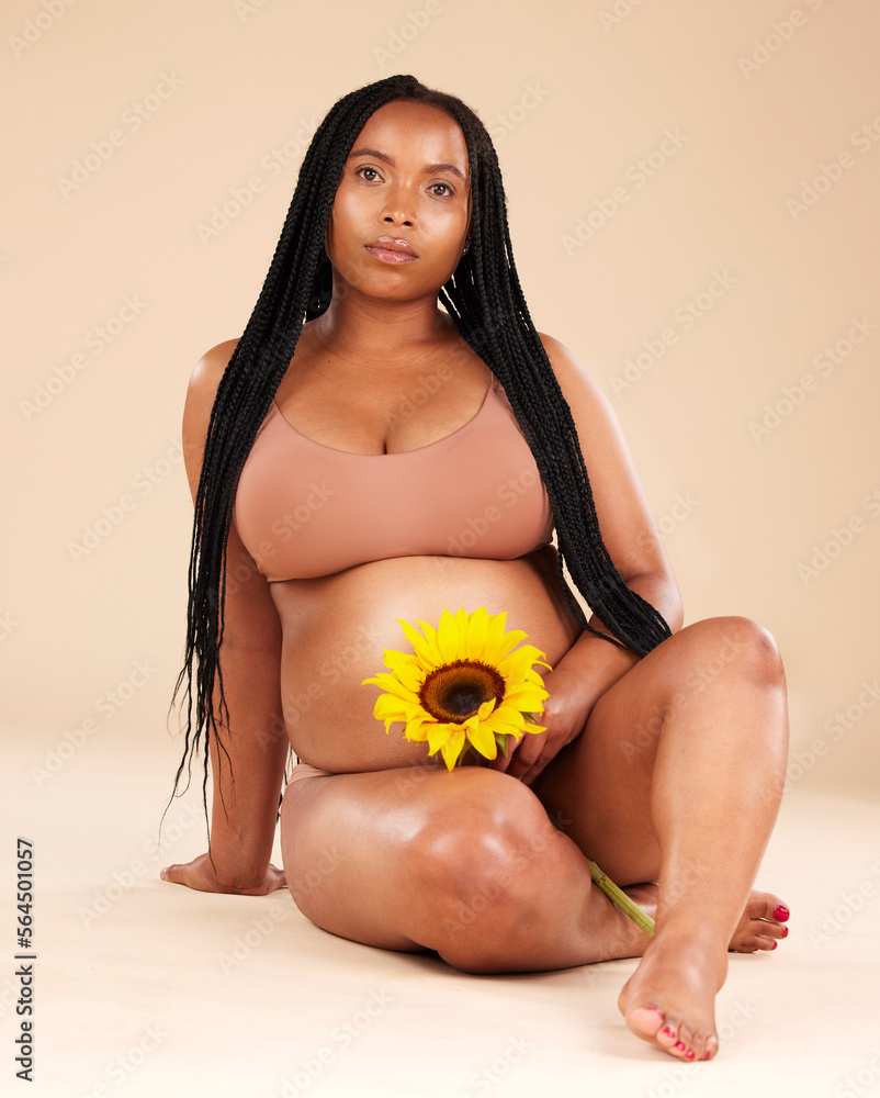 黑人妇女与花坐在一起，在肖像中怀孕，在ba工作室隔离护肤品