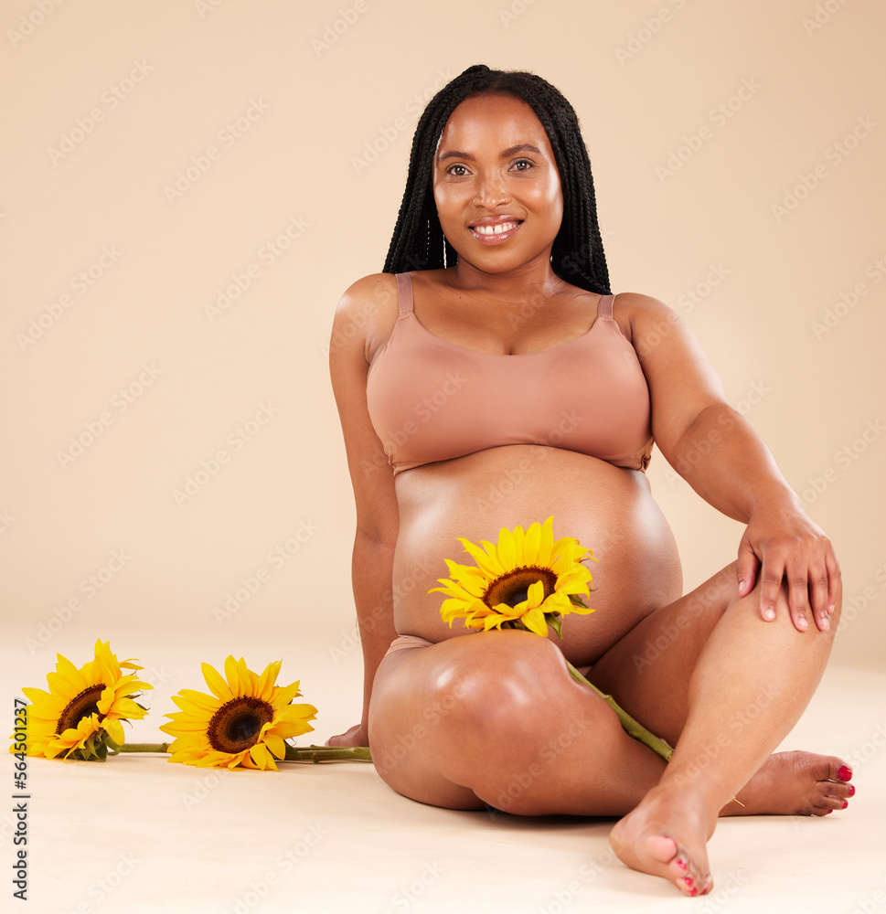 黑人女性与花坐在一起，在肖像和美丽中微笑怀孕，护肤隔离在st上