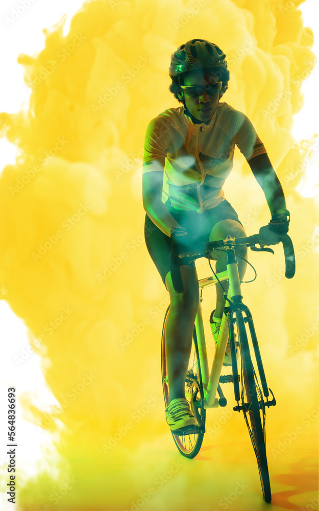 戴着眼镜和头盔的非裔美国女运动员在烟雾弥漫的背景下骑自行车