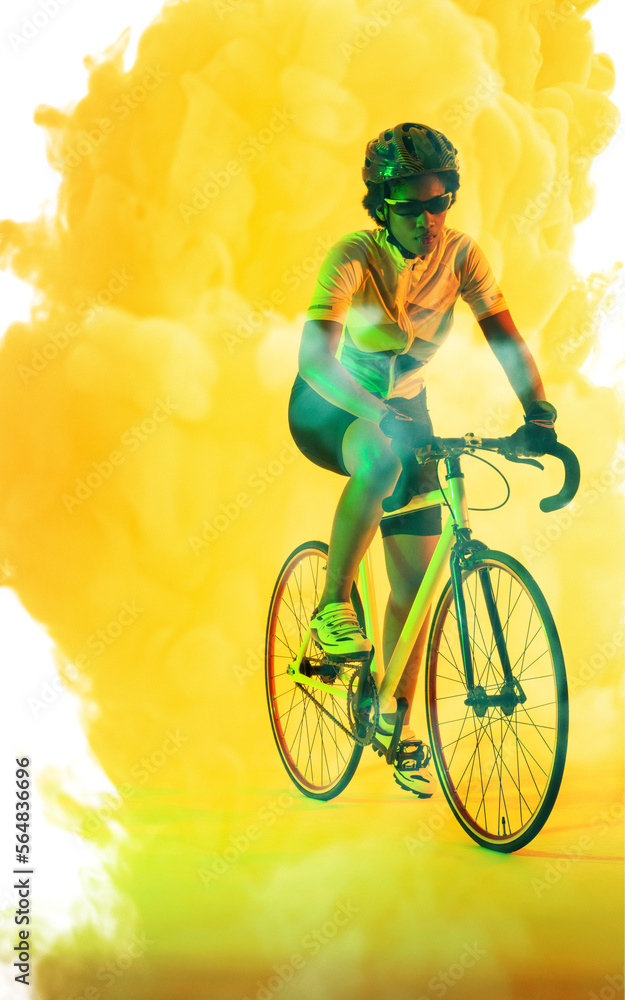 Full length of african american woman wearing glasses and helmet riding bike on smoky background