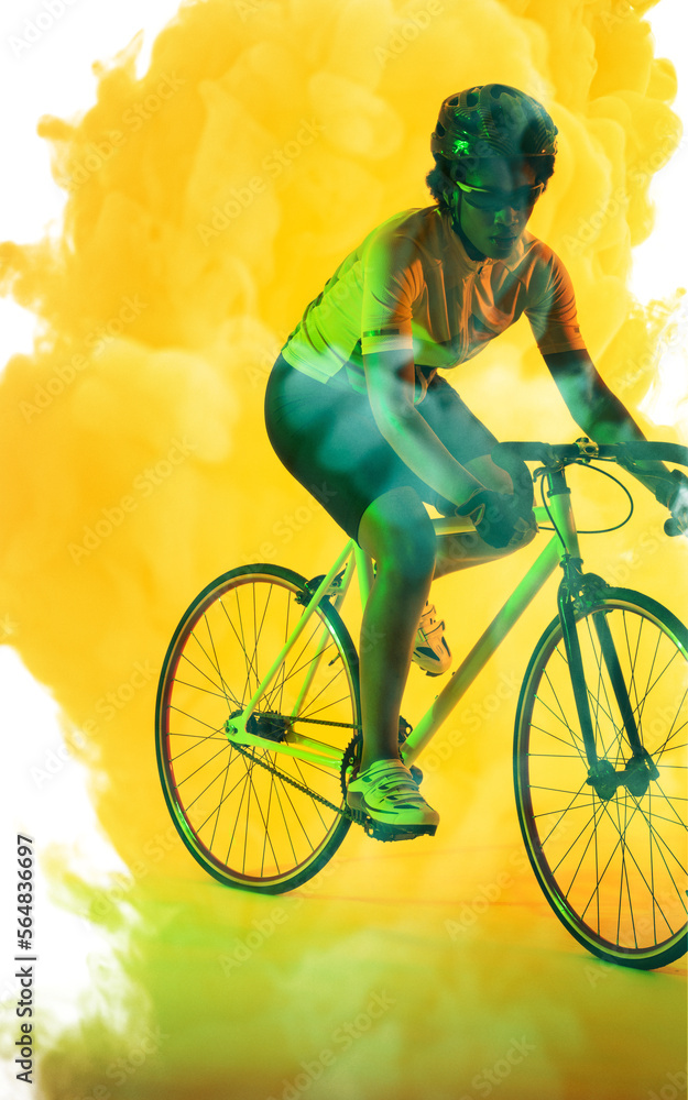 戴着眼镜和头盔的非裔美国女运动员在烟雾弥漫的背景下骑自行车