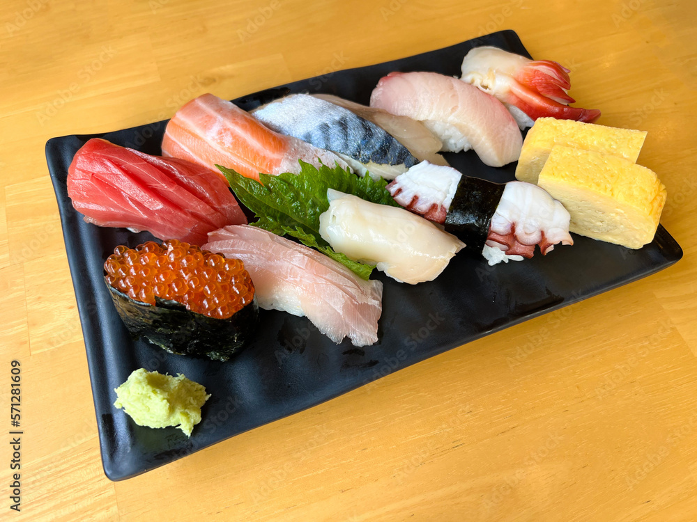 The premium Japanese sushi set place on black plate with wasabi
