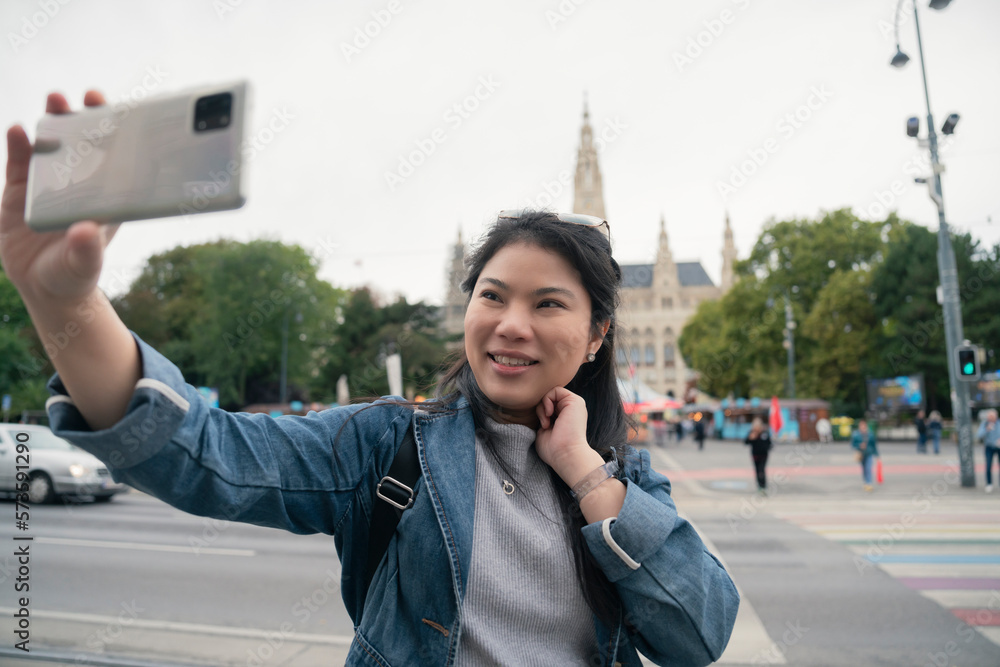 asian female woman  traveller enjoy holiday vacation city walking hand using smartphone taking photo