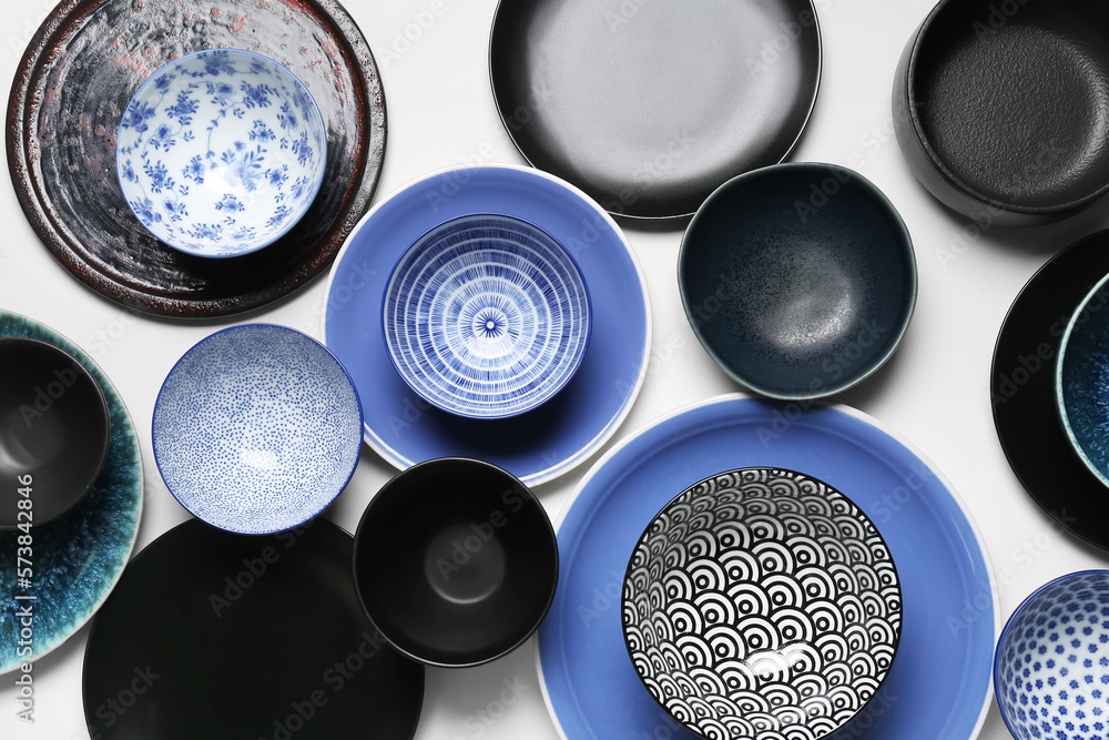 Composition with clean ceramic plates and bowls on white background